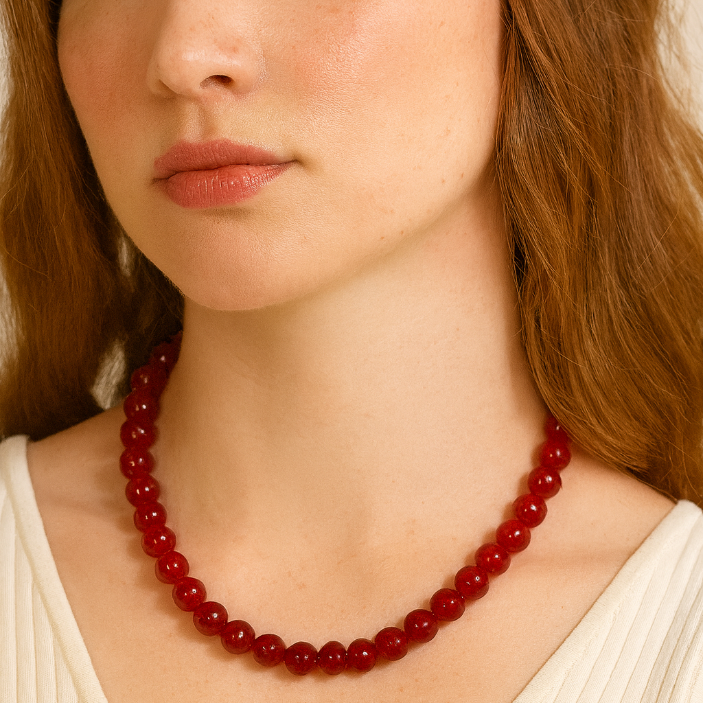 Red beaded necklace worn by a person with a neutral background