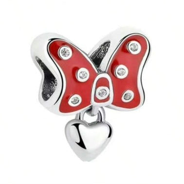 Butterfly charm with red wings and a heart on a white background