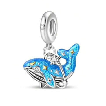 Blue whale charm with silver accents on a white background