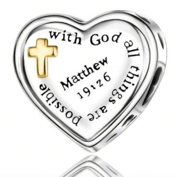 Heart-shaped charm with cross and engraved text on a white background