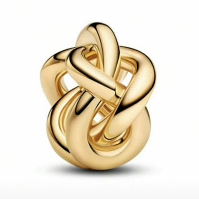 Gold knot-shaped jewelry piece on a white background