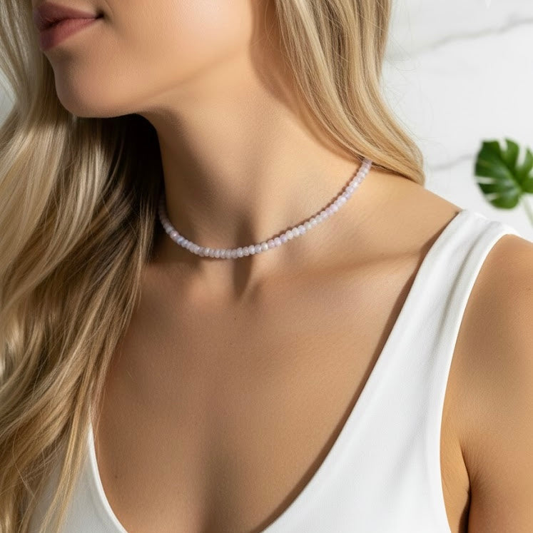 Pearl necklace worn by a model in a white top with a blurred background